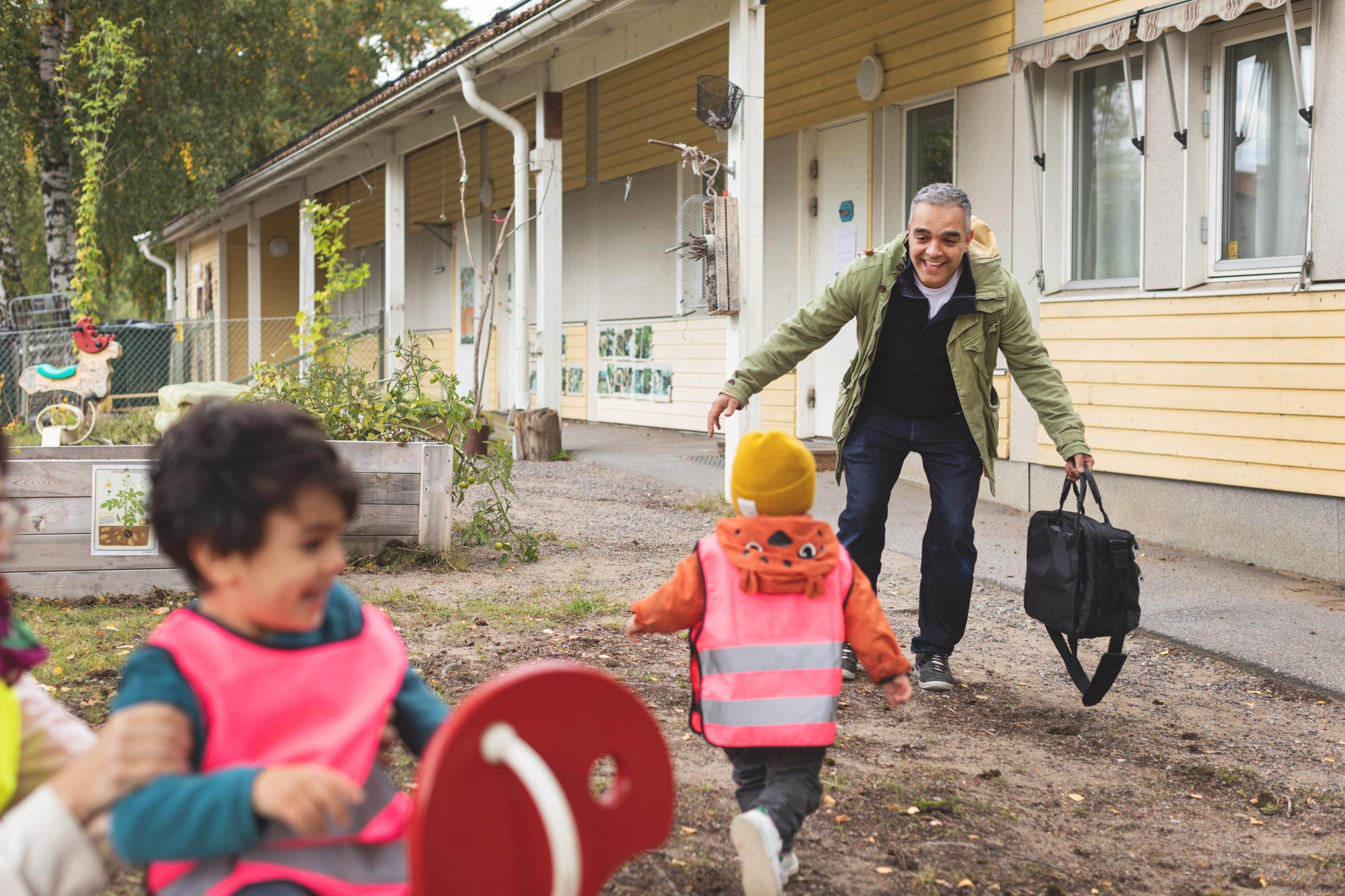 A father picks up his child from preschool.